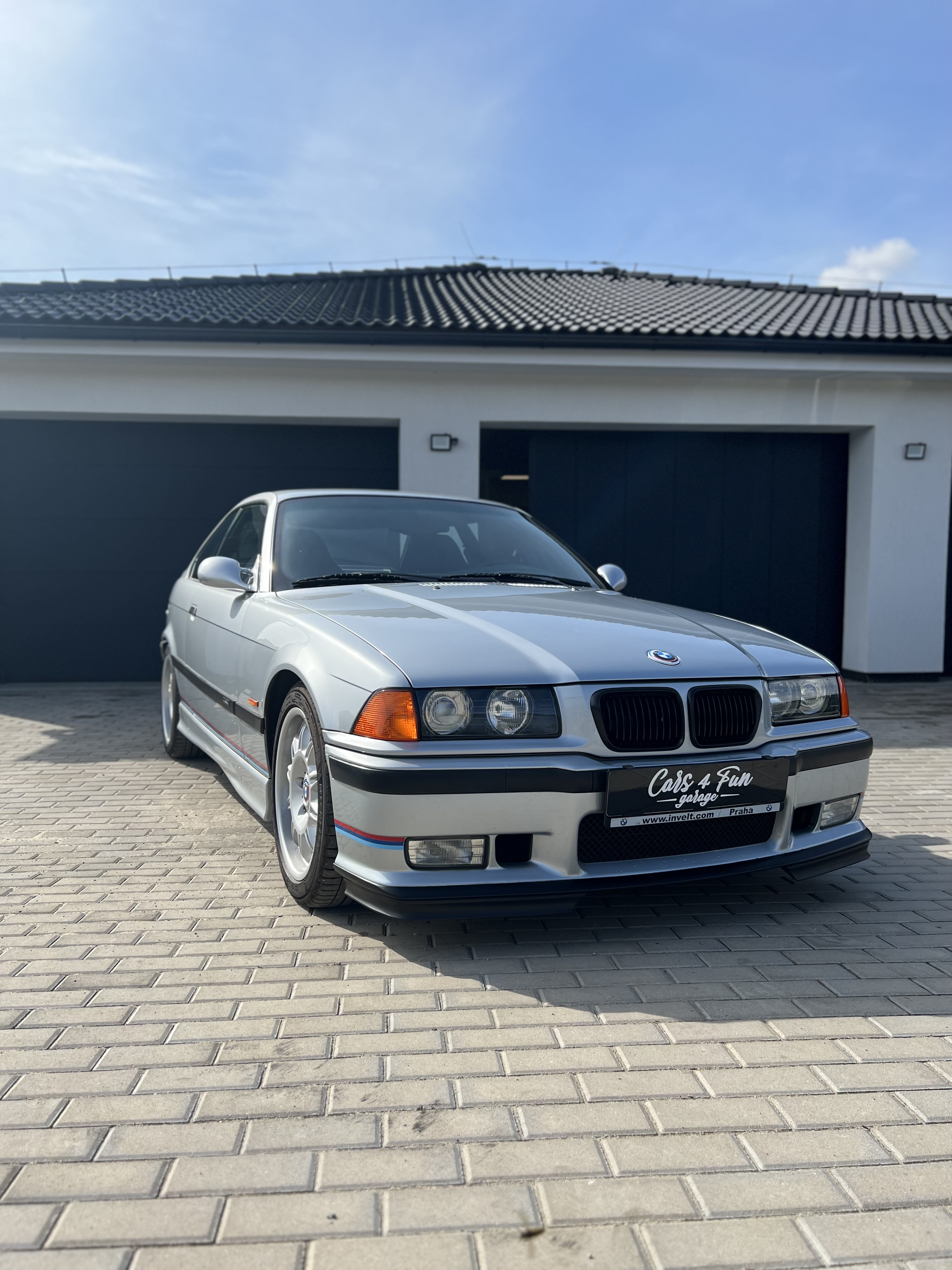 Stříbrné BMW E36 před garáží Cars4fun
